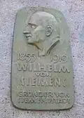 Plaque commémorative dédiée à Wilhelm von Siemens, fondateur de Siemensstadt, dans le parc Wilhelm-von-Siemens.