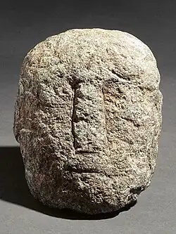 Tête sculptée en granit, Bibracte (IIe-Ier&nbsp;siècle&nbsp;av. J.-C.), avec visage très schématique.