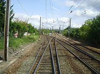 Bifurcation au nord de la gare d'Éragny - Neuville entre, à gauche, la ligne d'Achères à Pontoise et, en face, un raccordement qui permet de rejoindre la ligne de Saint-Denis à Dieppe, vue depuis la cabine de conduite d'une rame se dirigeant vers Pontoise.