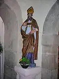 La statue d’un saint évêque située dans le porche