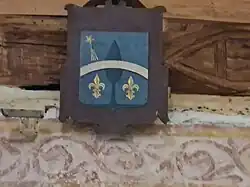 Blason armorié en cimaise et frise murale romane.
