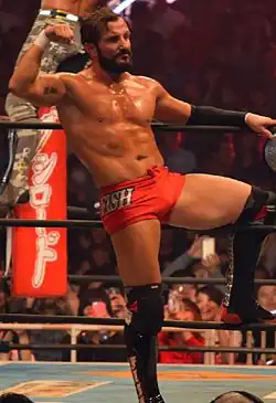 Photographie d'un catcheur en slip rouge montrant ses muscles.