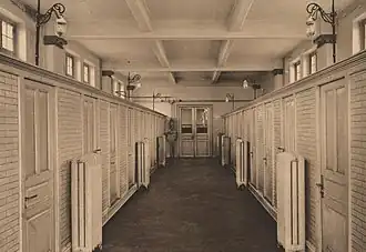 Photo noir et blanc montrant l'intérieur des douches de la piscine.