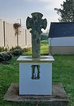 Croix de chemin « Prauds », autrefois située au milieu d'un pré et déplacée dans l'enclos au début des années 1990 par les services municipaux. Vue partielle de la sacristie.