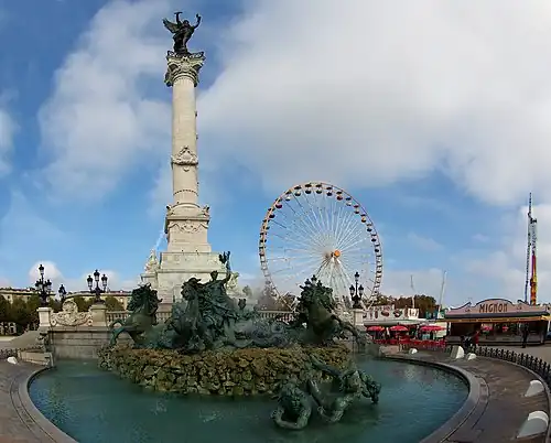 Colonne du monument aux Girondins et installations de la foire aux plaisirs.