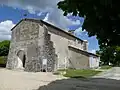 L'église avec ses maçonneries très modifiées . Fronton, contrefort, fenêtre latérale obstruée, sacristie.