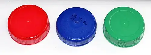 Bouchons de bouteilles de lait des 3 couleurs utilisées pour distinguer les 3 types de lait selon leur taux de matières grasses : le rouge pour le lait entier, le bleu pour le lait demi-écrémé et le vert pour le lait écrémé