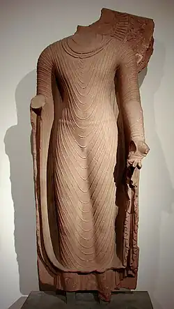 Bouddha acéphale en robe uttarâsangâ, daté du début du VIe&nbsp;siècle, école de Mathura, grès rose, Musée Guimet.