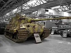 Un Tigre II camouflé, exposé au musée des blindés de Bovington. Le canon surplombe la proue du char de plusieurs mètres.