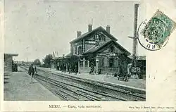 L'électro-sémaphore de la gare de Méru (type Lartigue - Nord), sur le quai à côté du bâtiment de la gare au début du XXe&nbsp;siècle. Le petit aileron dressé annonce l'arrivée d'un train sur la voie de gauche. Il a été déclenché à distance par le déploiement gravitaire de la grande aile du sémaphore de la gare précédente.