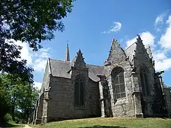 Vue du sud-est. Au-dessus du croisillon sud, apparaît le haut de la flèche. À droite, le chevet à trois pans. On remarque que les gargouilles reposent directement sur les contreforts.