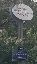 Plaque de rue avec bulle "quand-est-ce qu'on mange ?"