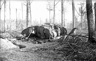 Des soldats allemands observent un char anglais Mark I détruit, probablement dans le « bois de Bourlon », Photo prise en novembre 1917.