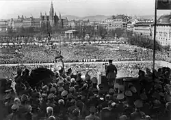 Photographie en noir et blanc d'Adolf Hitler, vu de dos, s'adressant à la foule rassemblée sur la Heldenplatz à Vienne  le 15 mars 1938