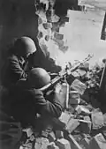 6. Début avril 1945, deux  hommes du Volkssturm équipés de casques tchèques durant les combats en Silésie. Ils sont armés d’une mitrailleuses MG 15