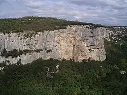 Photographie en couleur, montrant une falaise vue depuis un hélicoptère