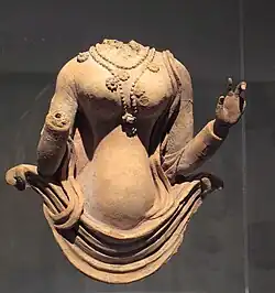Buste féminin émergeant d'une draperie. Terre séchée, VIIe&nbsp;siècle. Monastère de Fondukistan, niche E. Vallée du Ghorband. Afghanistan. Musée Guimet.