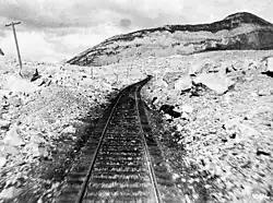 Chemin de fer entouré de débris rocheux.