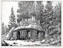 Un homme tenant un livre et un chien, assis devant une cabane en pierres au toit de chaume. Derrière, des sapins.