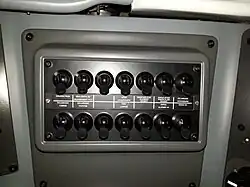 Zoom sur les commandes à droite du conducteur, dont « ouverture du disjoncteur » et « éclairage de la cabine ou des passagers ».