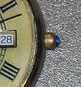 Un cabochon de saphir sur la couronne d'une montre pour homme.