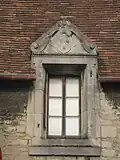 Photographie des armoiries sur une lucarne.