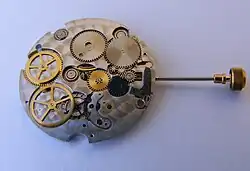 Mouvement laissant apparaître la couronne, la tige, et la tirette.