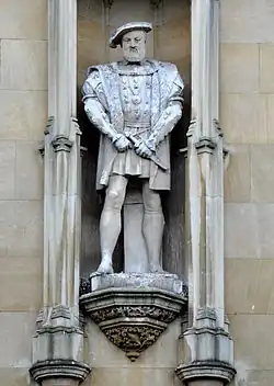 Statue blanche d'un homme portant une ample tunique située dans une niche dans un mur
