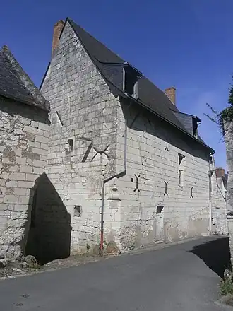 Photographie en couleurs d'un bâtiment au haut pignon pointu.