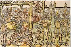 Peinture représentant une dizaine d'hommes, femmes et enfants emplumés autour d'un festin constitué d'autres hommes. En arrière-plan se trouvent des bateaux européens sur la mer.