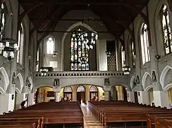 La nef vers l'entrée et le vitrail de la façade.