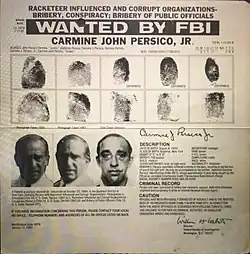 Photo d'une affiche en noir et blanc avec des photos des empreintes digitales et du visage du criminel recherché sous le texte "WANTED BY FBI : CARMINE JOHN PERSICO JR"