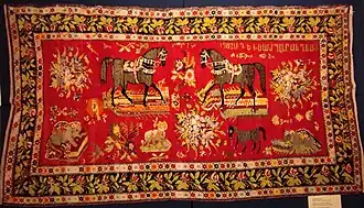Tapis de couleur rouge et dorée avec deux motifs de chevaux en son centre