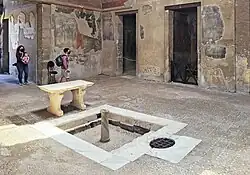 sol avec un bassin carré bordé de dalles blanches et une table en pierre blanche