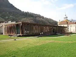 Photographie en couleurs d'un bâtiment moderne entouré de pelouse.