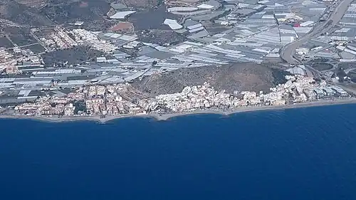 Castell de Ferro : la plage du Sotillo&nbsp;(es), le mont du château, la N-340 de part et d'autre du mont, la rambla del Hornillo bordée de serres à droite, El Romeral&nbsp;(es) en recul sur la gauche