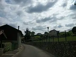 Le puits sur le bord gauche, la salle des fêtes derrière le cèdre et la mairie à droite du lampadaire en premier plan