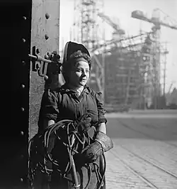 Une soudeuse sur un chantier naval, au Royaume-Uni, en 1943. En arrière-plan : un navire en construction.
