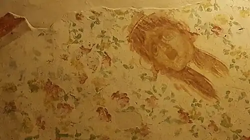 Au plafond : masque tragique,  décor floral.