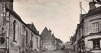 Photographie ou carte postale représentant le centre-bourg de Fondettes au début du XXe&nbsp;siècle, avec la nef de l'église Saint-Symphorien de Fondettes, à gauche et la rue principale au centre.
