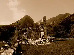 Image sépia des ruines d'un château avec des montagnes en arrière-plan.