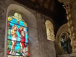 Angle nord est du chœur, baie préromane et vitrail de Jean-Baptiste.