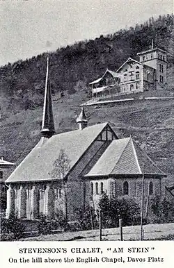 Photo en noir et blanc. La chapelle anglaise de Davos et derrirèe, sur une colline, un grand chalet