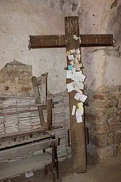 Le même piédroit nord, vu depuis la nef. La croix est parsemée d'ex-voto.