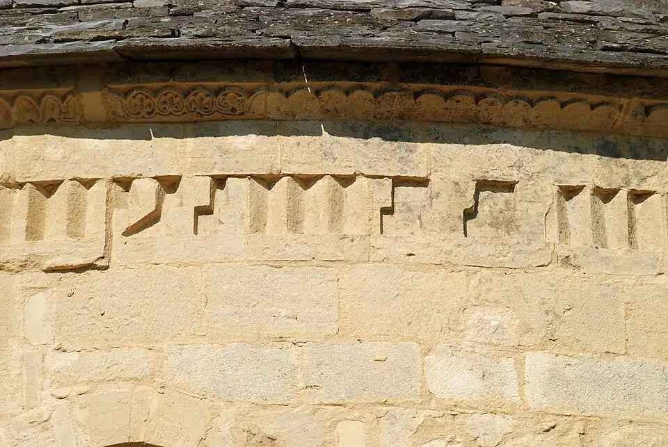 Frise de dents d'engrenagemêlée de motifs inspirés de la « grecque ».