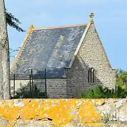 Vue en couleur d'une chapelle en arrière-plan d'un mur jaune.