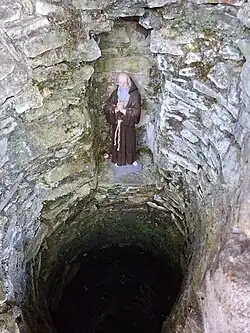 Statue et fontaine maçonnée.