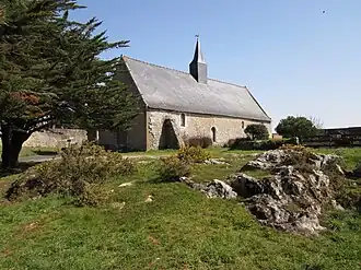 Vue d'une chapelle avec terre-plein herbeux en premier plan.