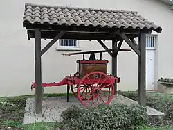 Photographie de la pompe à bras des pompiers sous un abri.