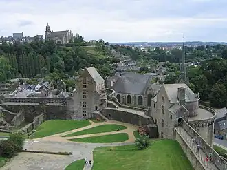 Photographie où l'on voit la cour du château ainsi qu'une église en hauteur sur l'arrière-plan.
